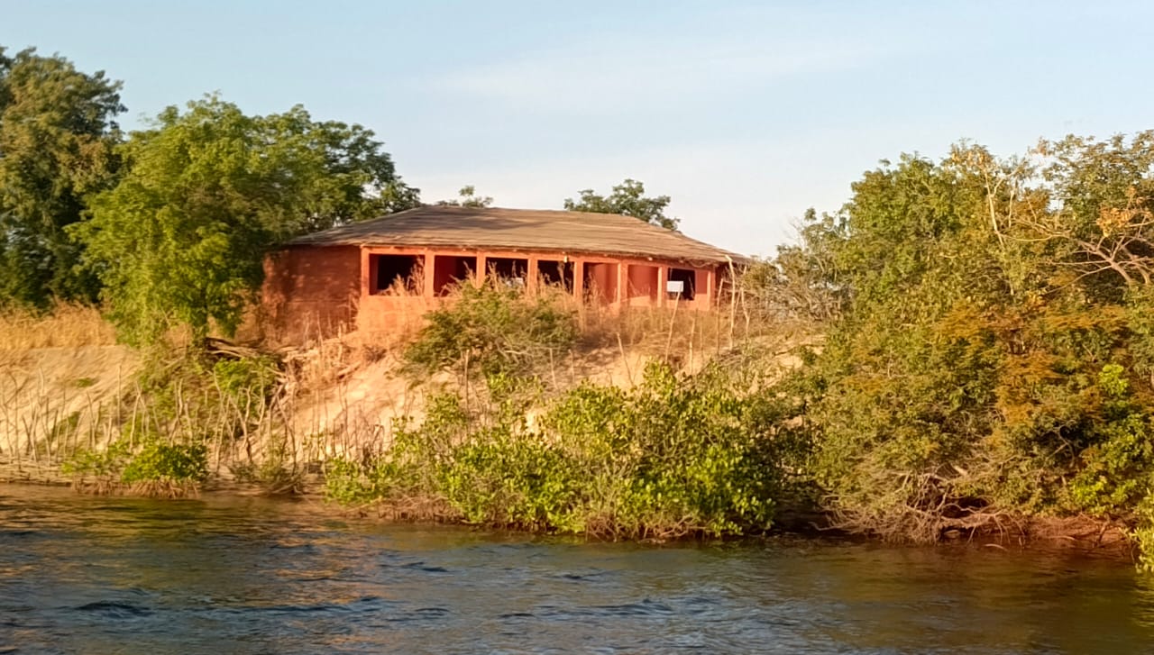 Eco-lodge circondato dalla vegetazione lungo un corso d'acqua.